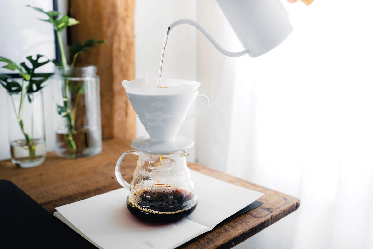 Water being poured into a filter filled with coffee grounds to make a pour-over coffee.