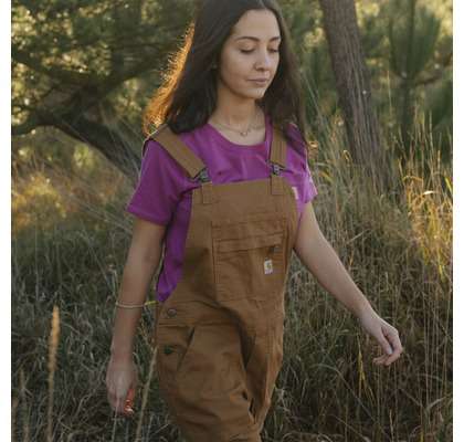 woman walking wearing Carhartt overalls