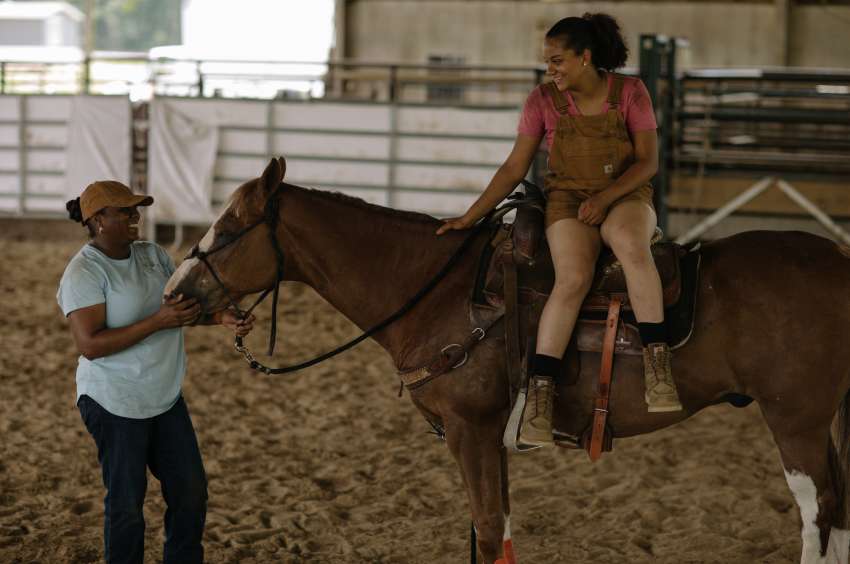 mother petting horse with daughter