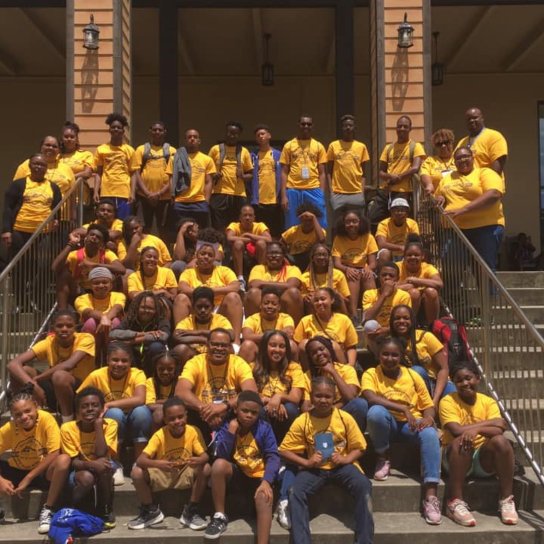 Group photo of a large group of children and teens wearing yellow shirts