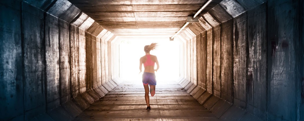 Woman jogging through tunnel