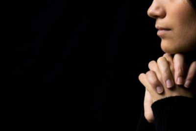 Woman praying with black background