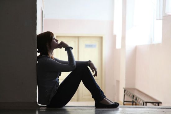 Girl praying in a hallway
