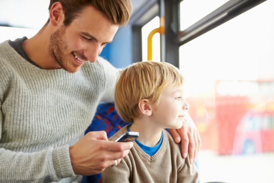 Man looking at smartphone while hanging with son.