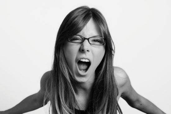 Angry teen girl wearing glasses, yelling