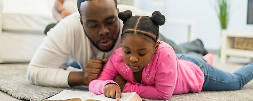 Dad and daughter studying the Bible together