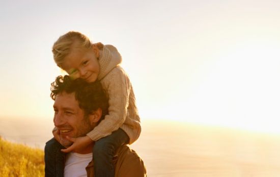 Single father and child walking on the beach.