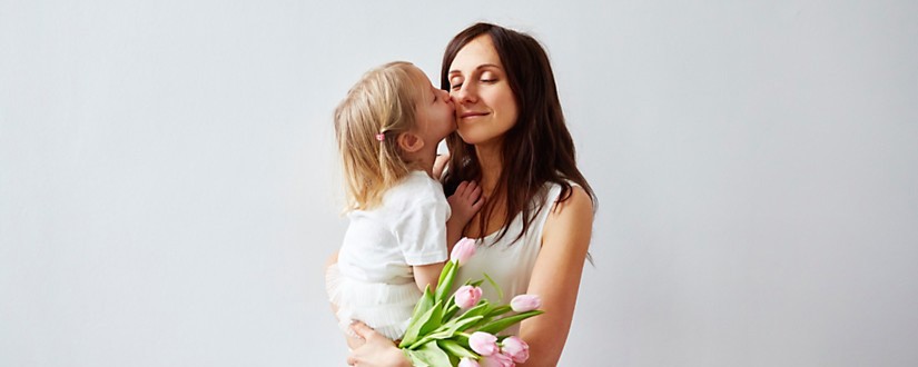 Mom with flowers holding young daughter