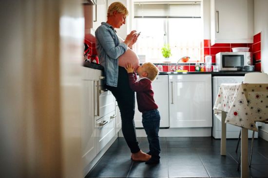 Pregnant mom looking at a smartphone.