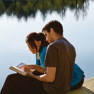 couple reading by lake
