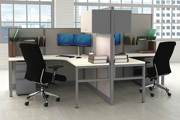 USA-made Corben Collection cubicle with two workstations, black chairs, dual monitors, and desk organizers in a bright office space.