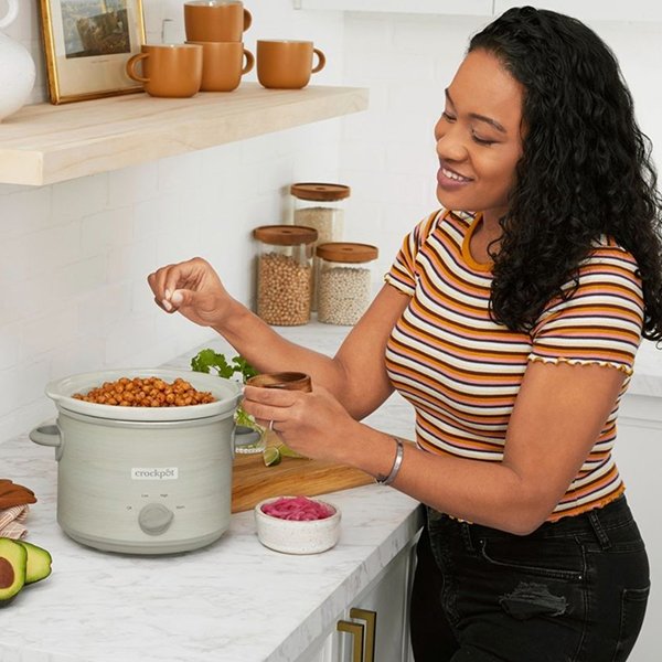woman preparing recipe in slow cooker