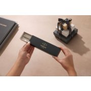 Person opening a box with a pen in it with gift boxes near image number 5