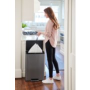 woman in kitchen taking trash bag out of dual stream step-on garbage and recycling can image number 8