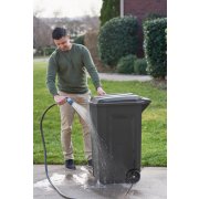 man cleaning outdoor refuse bin with hose image number 7