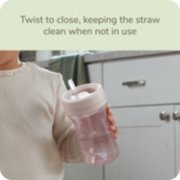 Child holding Nuk sippy cup with twist to close, keeping straw clean when not in use image number 4