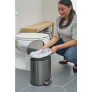 women using small garbage can in bathroom image number 8