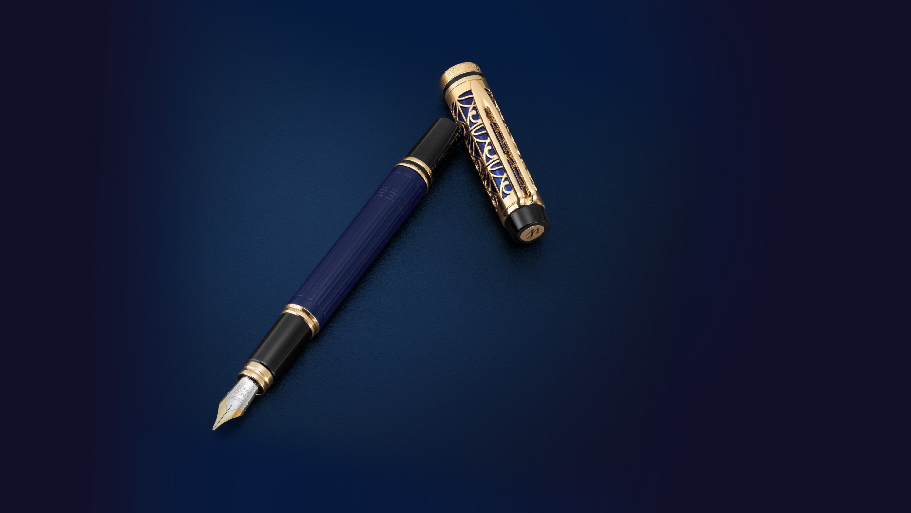 Luxury fountain pen with intricate gold and black design on cap against a dark background.