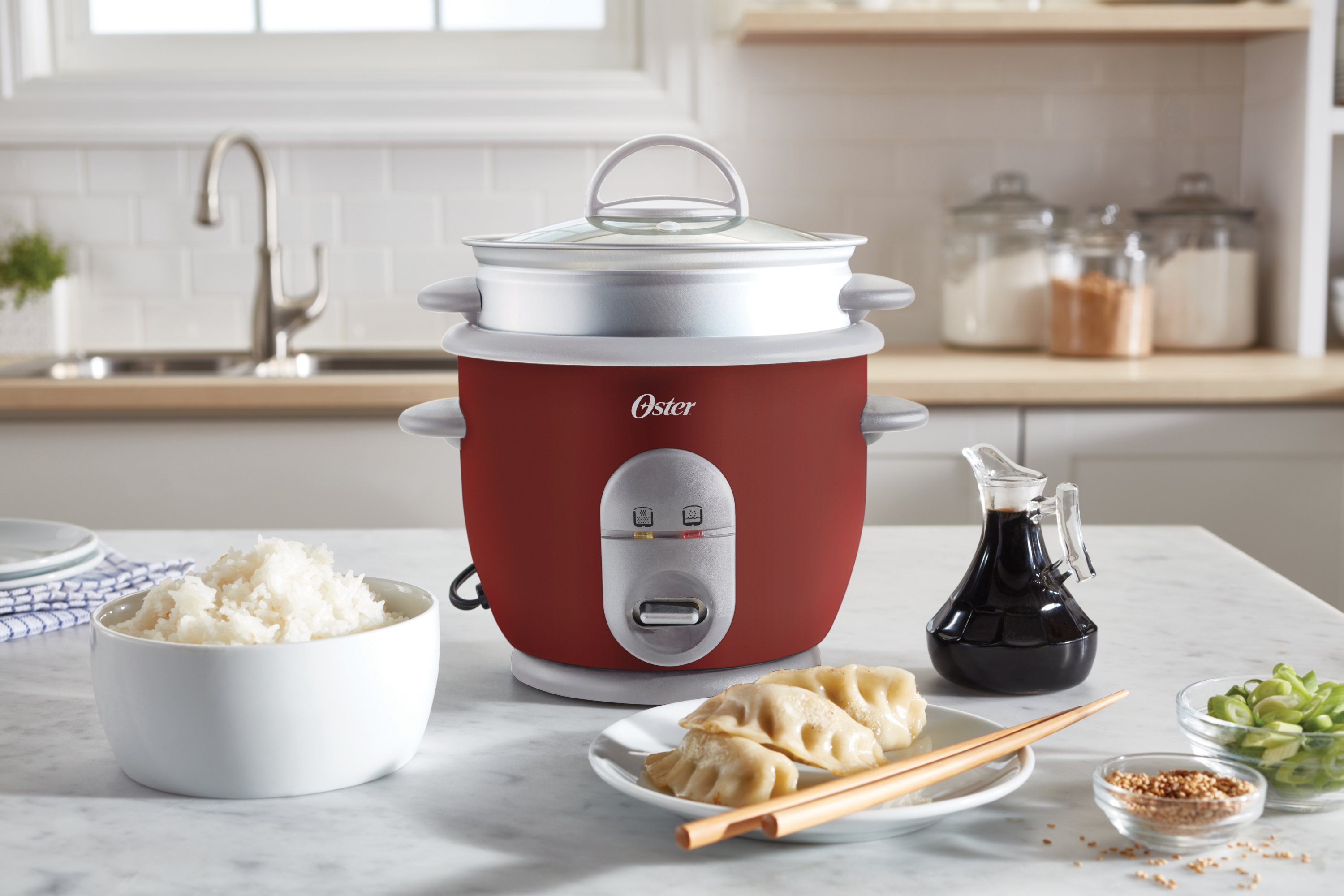 https://s7d9.scene7.com/is/image/NewellRubbermaid/4722000000-oster-rice-cooker-with-steamer-red-straight-on-lifestyle-1