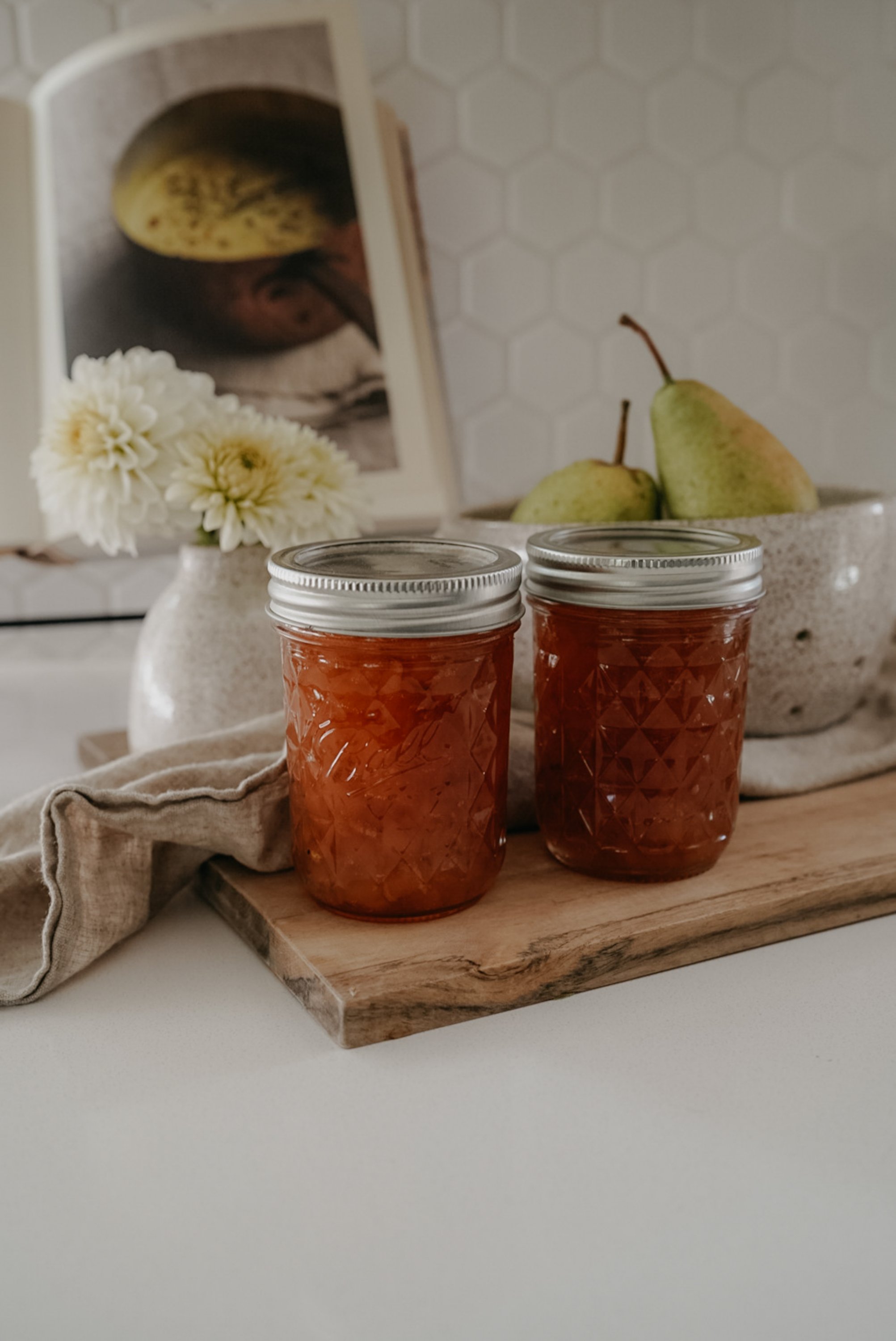 two jars of canned pear preserves on table
