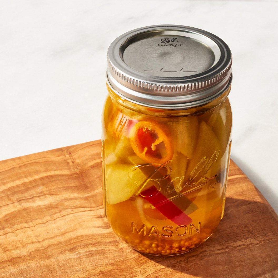 a canning jar filled with food on cutting board