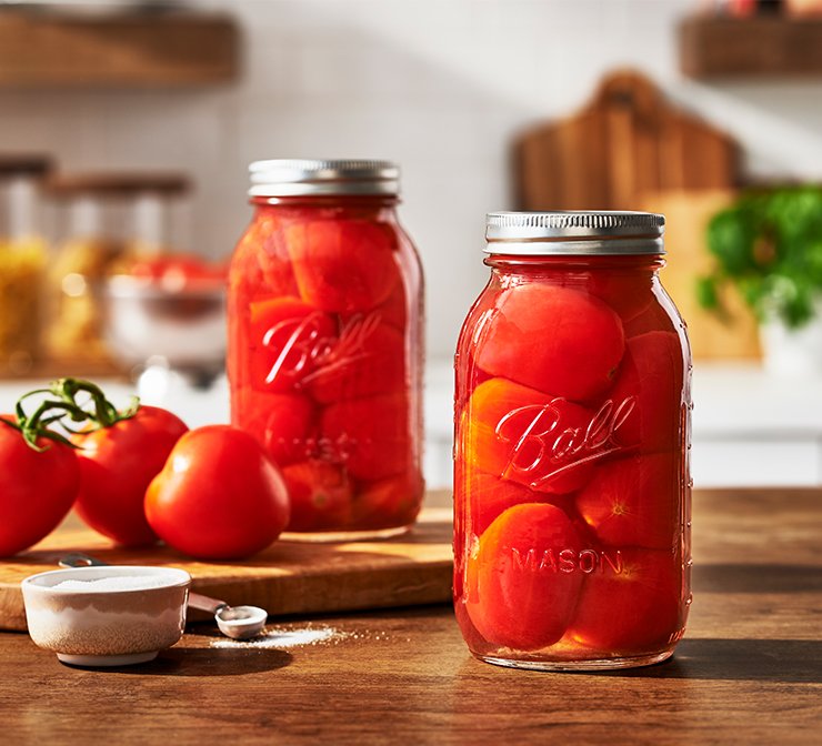 Glass canning jars with lids and bands preserving tomatoes