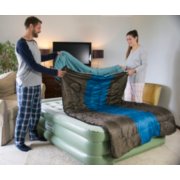 Couple setting up two person sleeping bag on top of air bed image number 7