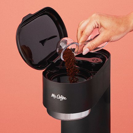 Putting coffee grounds into a coffee maker