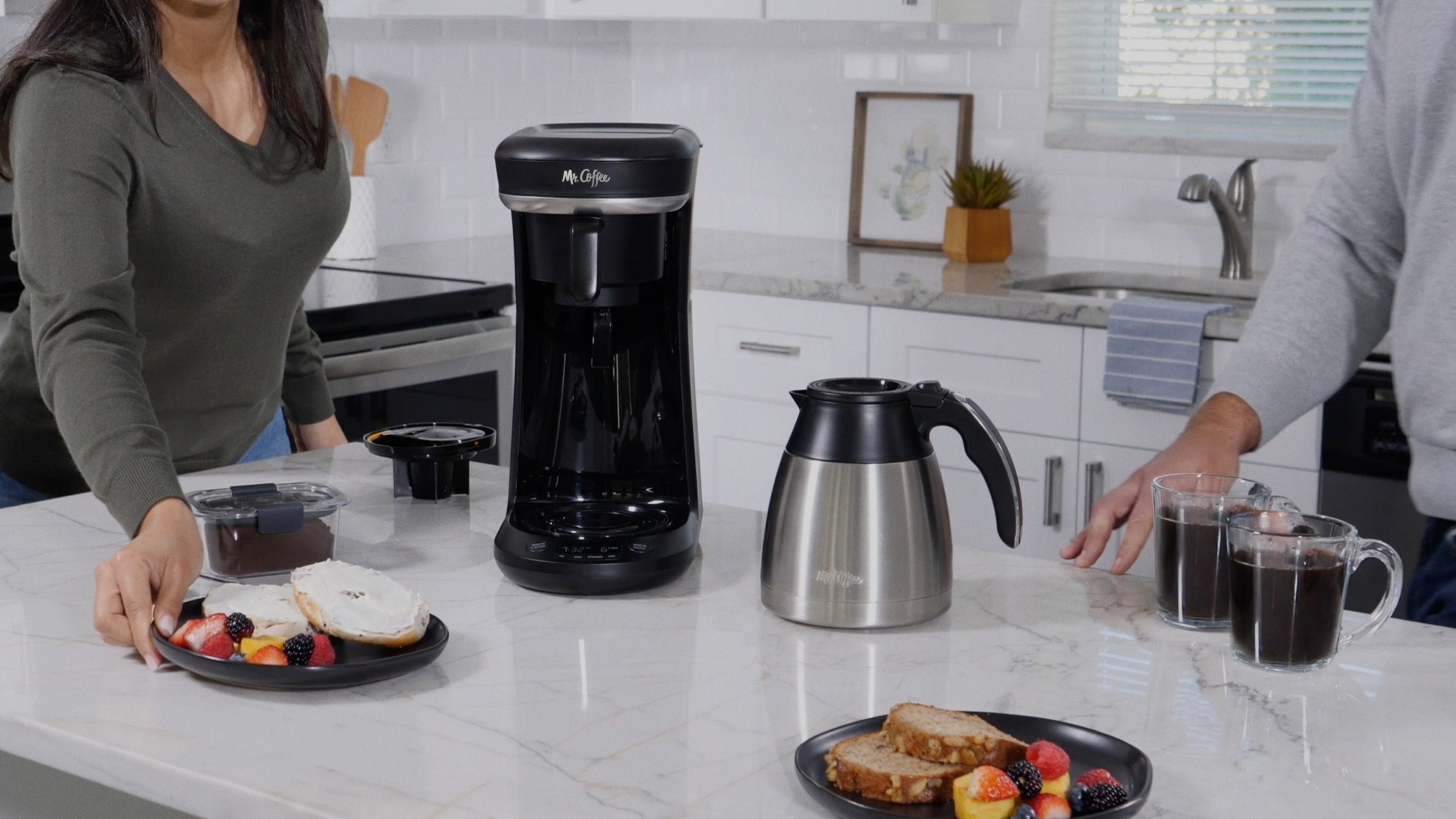 coffee maker with thermal carafe in kitchen with people and breakfast foods
