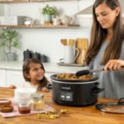 a woman and child cooking on table with slow cooker image number 3