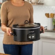 a woman holding a slow cooker of food image number 6