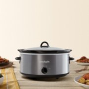 a stainless steel slow cooker with food on table image number 2