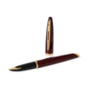 A Carene fountain pen with gold trim laid next to a pen cap stood upright. image number 4