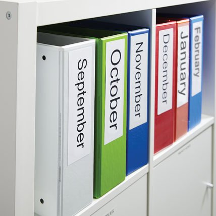 Colored binders in a shelf with large labels for each month.