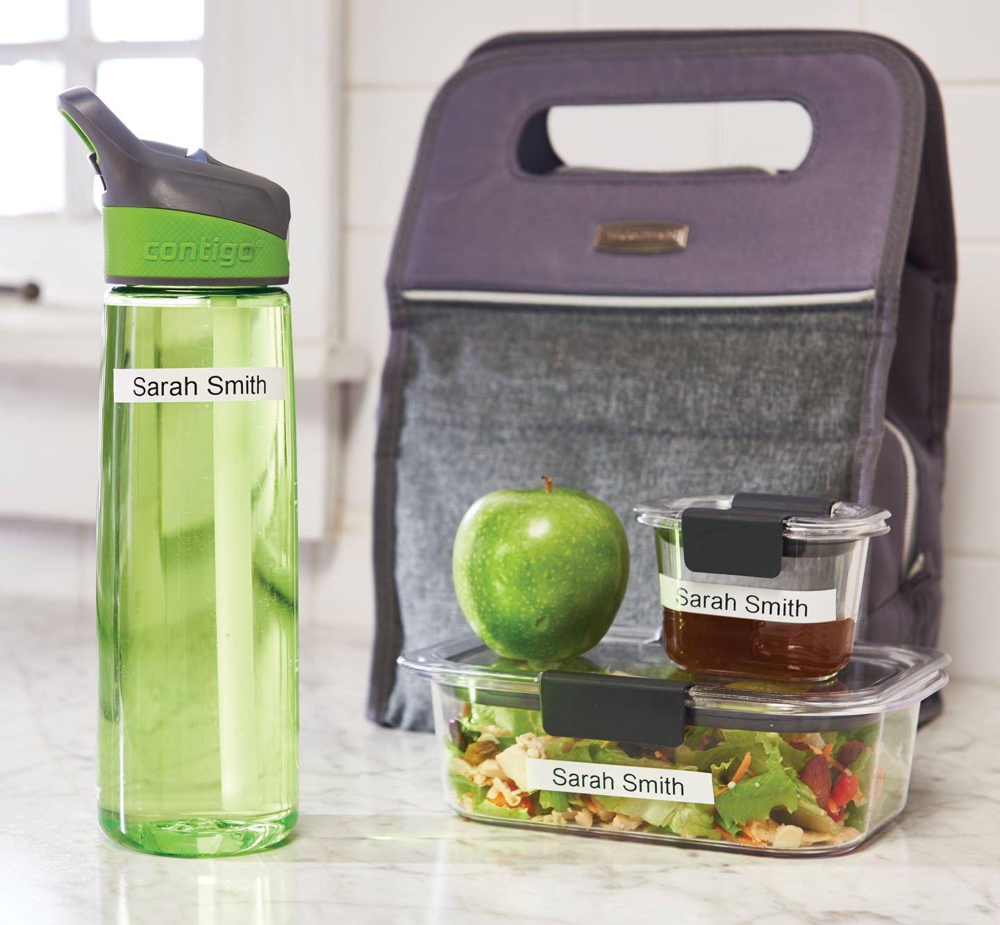 Name labels on a water bottle and food storage containers.