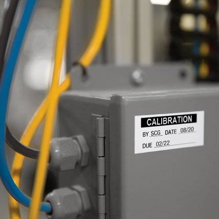 A labeled metal electrical box that reads calibration and due date.