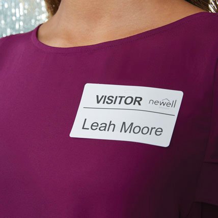 A woman wearing a visitor name badge.