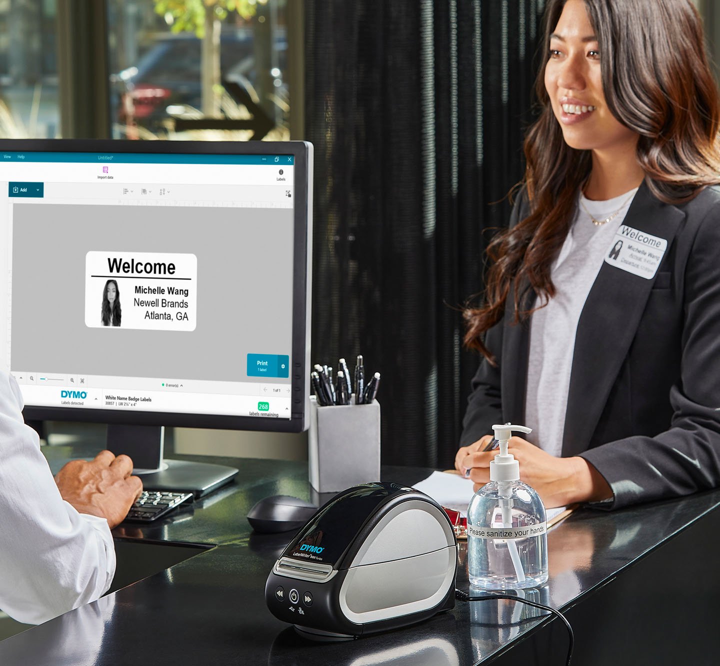 A person using a computer to create and print a welcome label for a visitor.