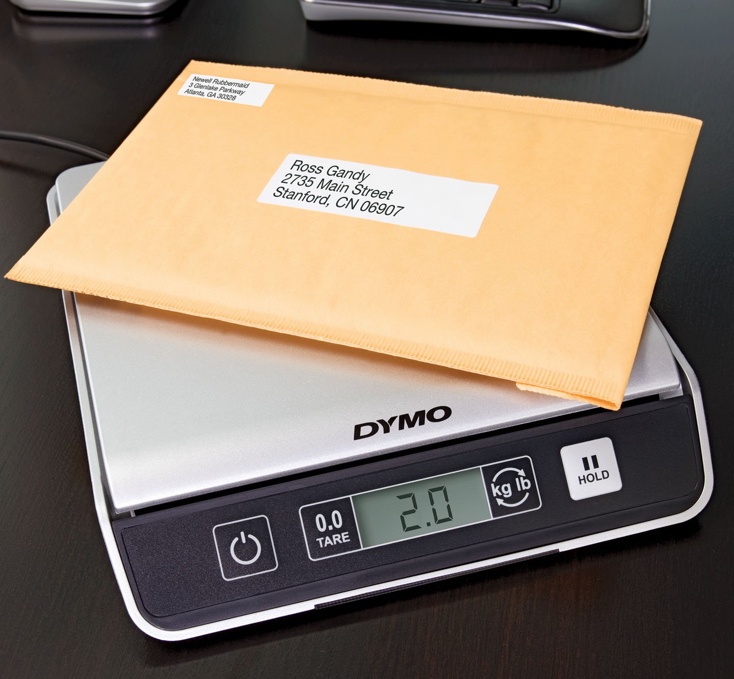 A labeled package being weighed on a scale.