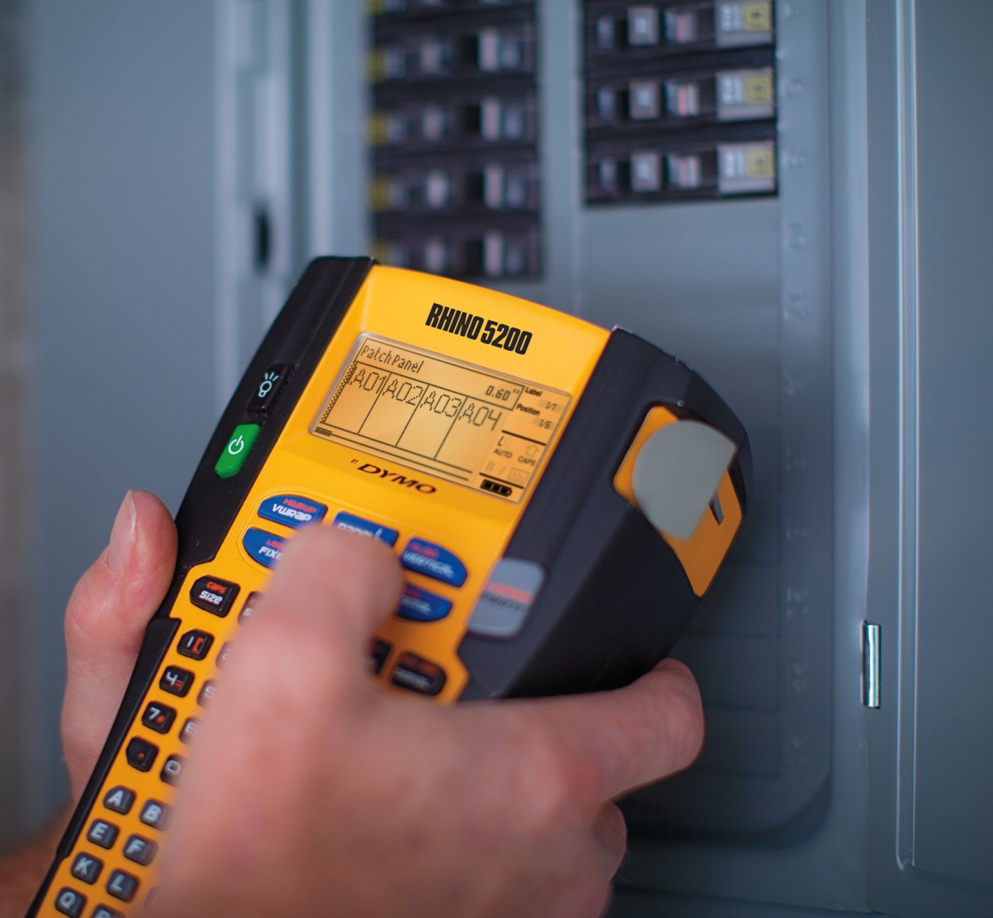 A person using a Rhino 5200 to create labels for a patch panel.