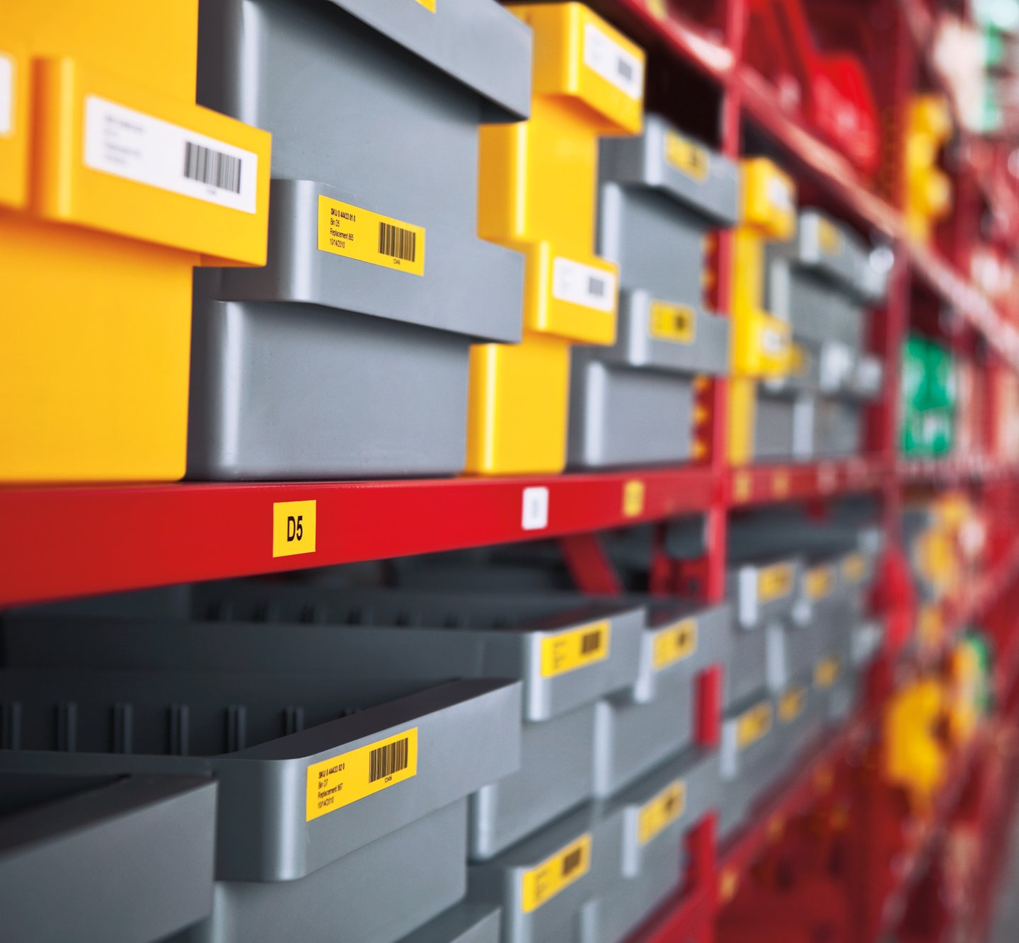 Rows of plastic bins with white and yellow barcode labels.