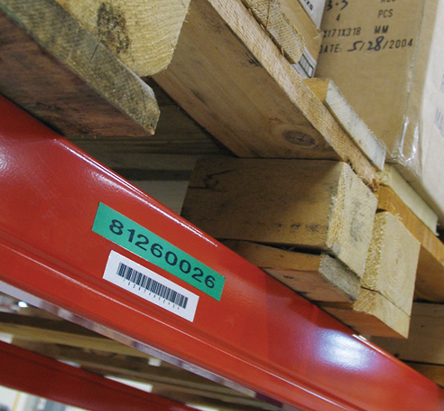 Wooden pallets on a warehouse shelf with a barcode label.