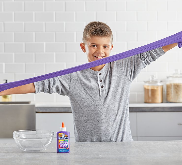 Colored glue bottle and child stretching purple slime