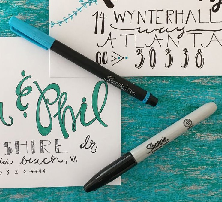 Sharpie marker and pen next to hand made invitations
