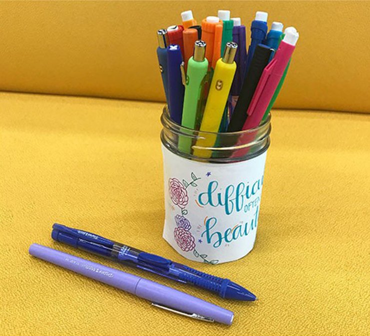 Paper Mate pens and pencils in a glass pencil holder