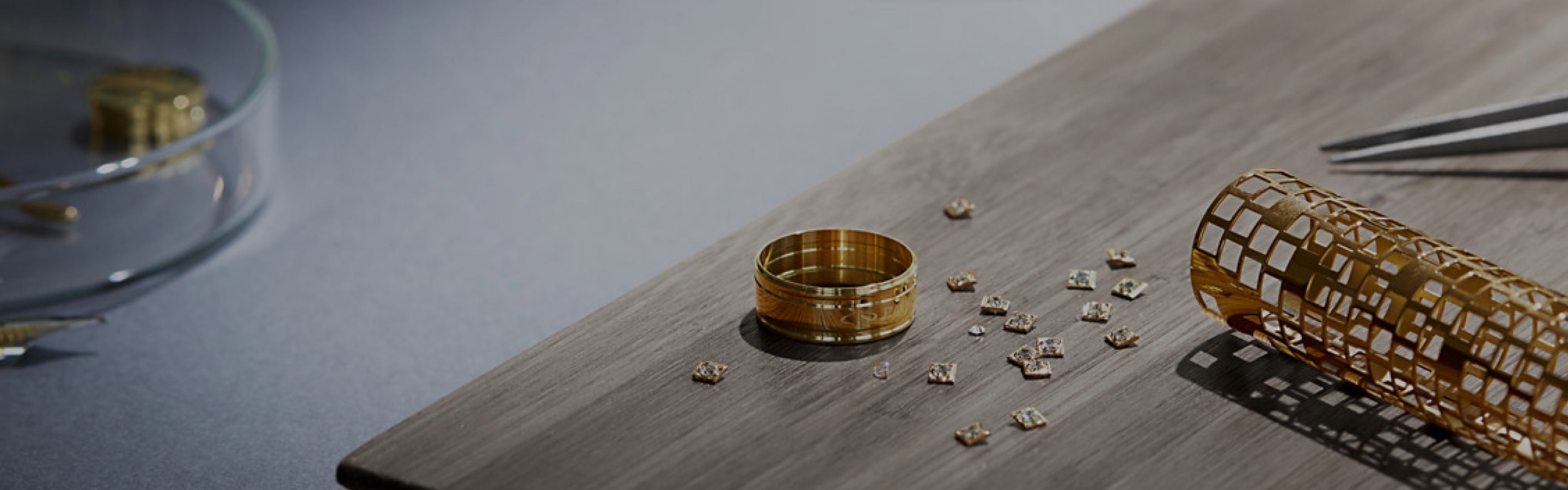 Squares cut from a gold cylinder next to a gold ring.