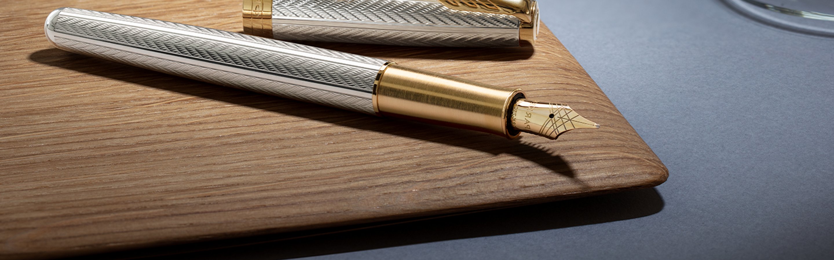 A Sonnet silver mistral fountain pen laid on a wooden board.