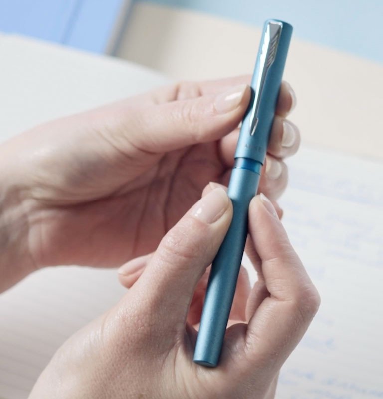 person holding fountain pen