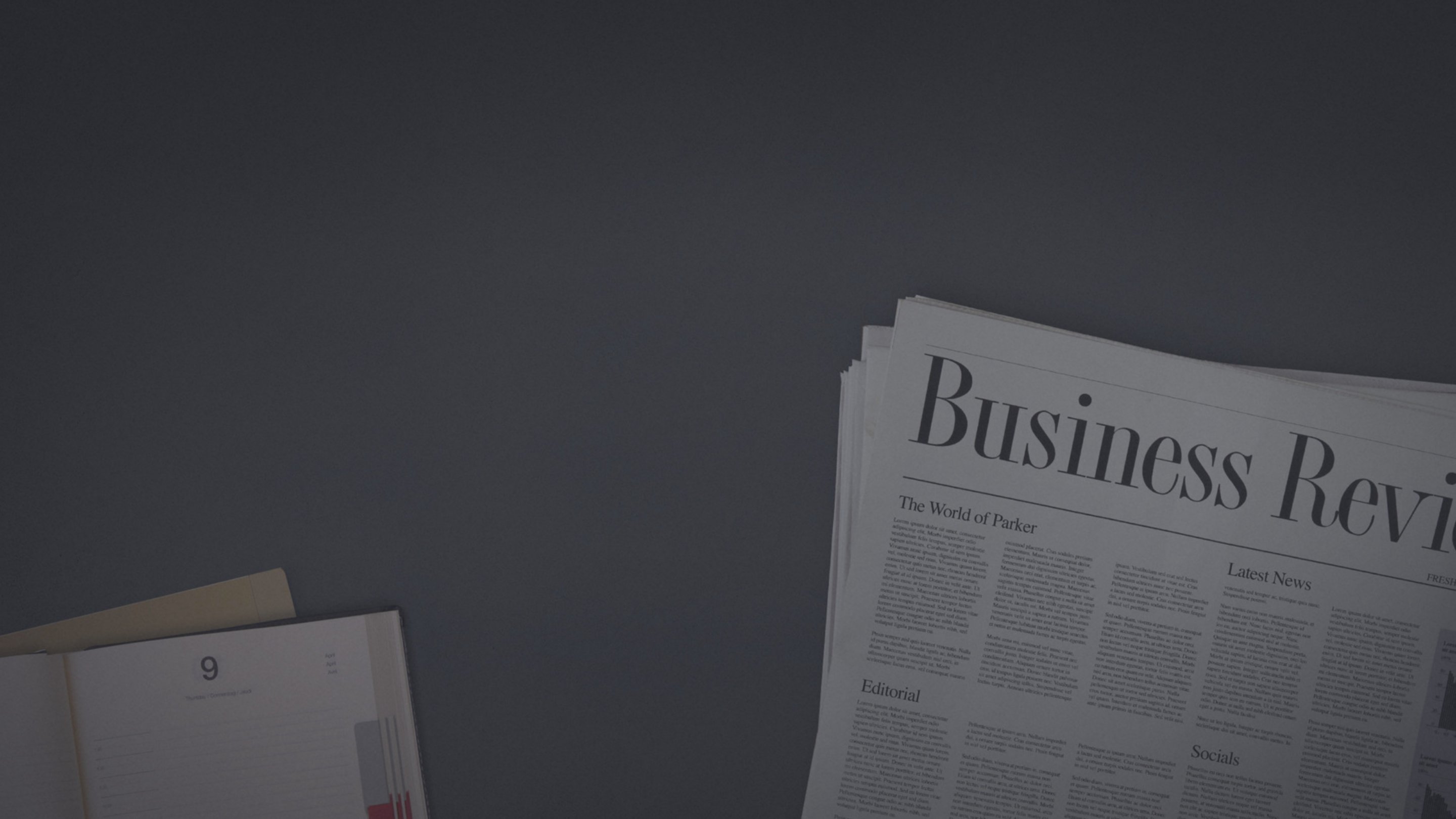 A newspaper and scattered documents on a desk.