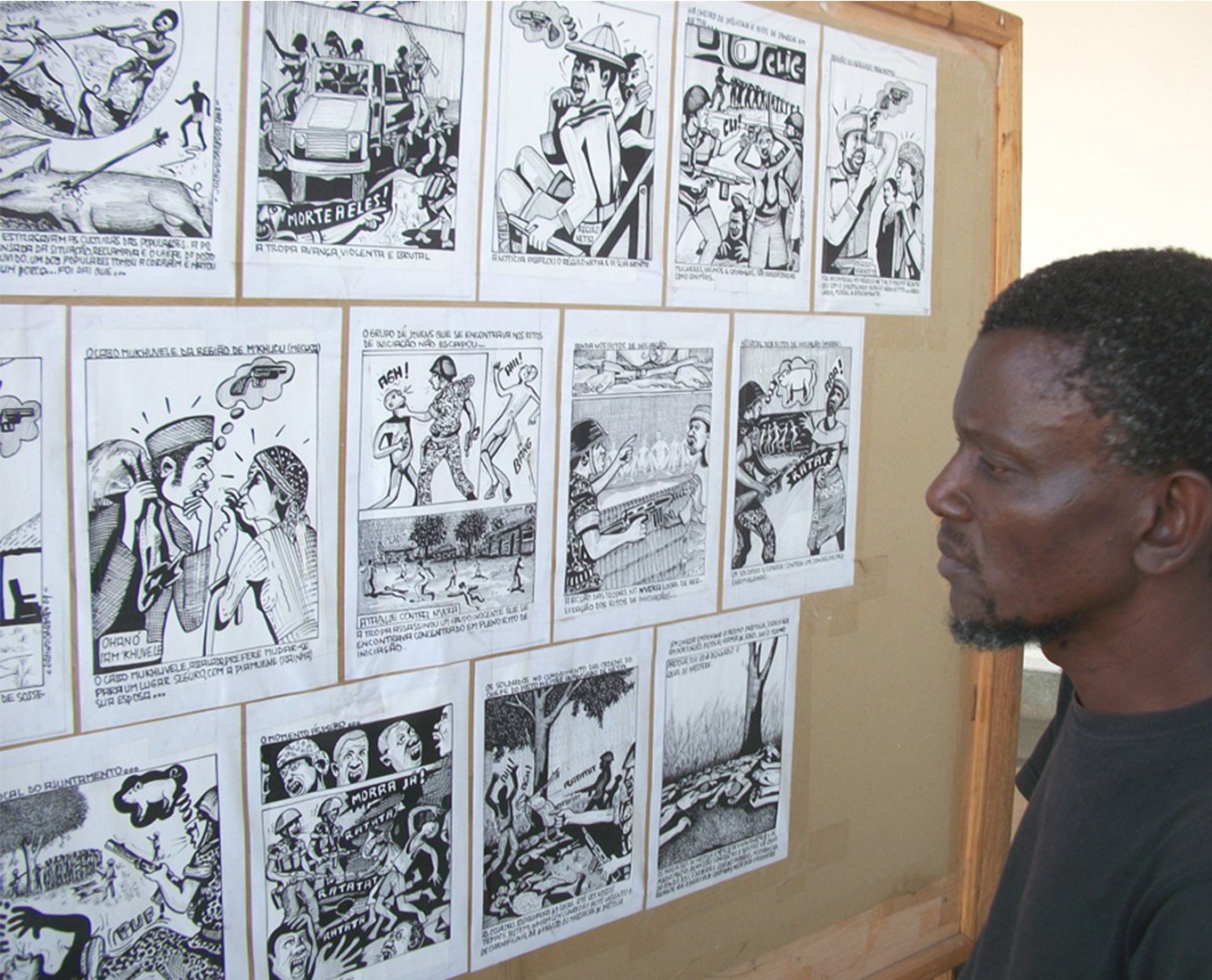A man reviewing comic book panel sketches.